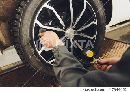 Car Tire Pressure Check in the Auto Service Garage. Car Tire Pressure Check in the Auto Service Garage. 47944462