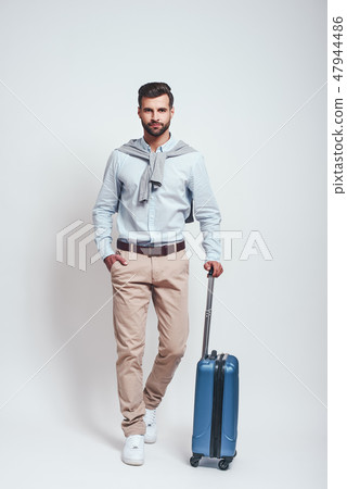 Time for adventure. Full length of charming bearded young man with a luggage keeping one hand in his 47944486