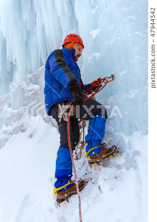 ice climber checks the reliability of the anchor ice climber checks the reliability of the anchor 47944542