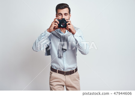 Smile! Close up photo of handsome male photographer in casual clothes who is taking photos with Smile! Close up photo of handsome male photographer in casual clothes who is taking photos with 47944606