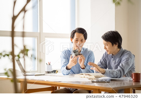 A young male employee who learns from the trustworthy seniors the studies of first class architects and studies pleasantly happily 47946320