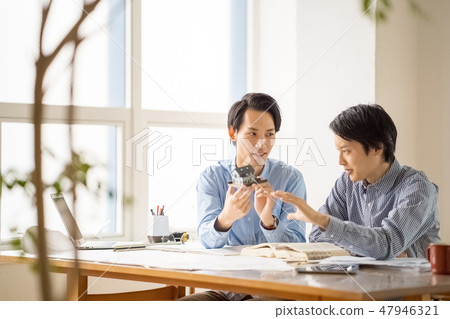 A young male employee who learns from the trustworthy seniors the studies of first class architects and studies pleasantly happily A young male employee who learns from the trustworthy seniors the studies of first class architects and studies pleasantly happily 47946321