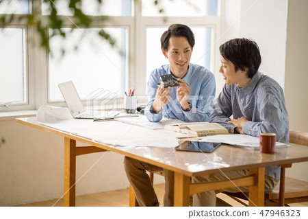 A young male employee who learns from the trustworthy seniors the studies of first class architects and studies pleasantly happily 47946323