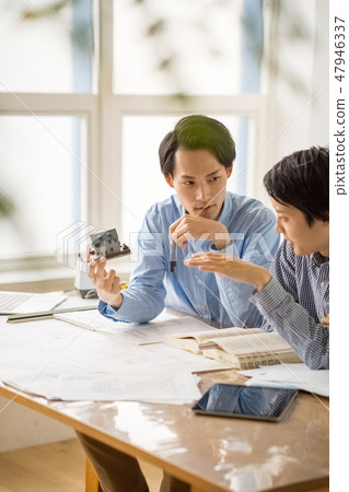 A young man design businessman who is considering to comply with the Building Standards Law under the request of renovation renovation work A young man design businessman who is considering to comply with the Building Standards Law under the request of renovation renovation work 47946337