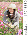 Portrait of smiling asian female smelling blooming flowers 47946650