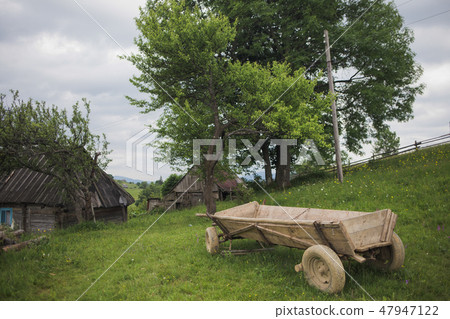 Old brown house, barn and wooden cart situated 47947122