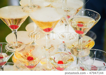 Pyramid of many empty glasses with red cherries 47947144