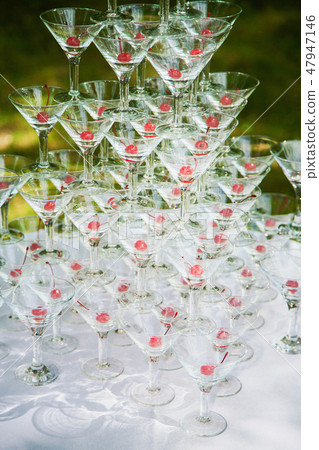 Pyramid of many empty glasses with red cherries Pyramid of many empty glasses with red cherries 47947146