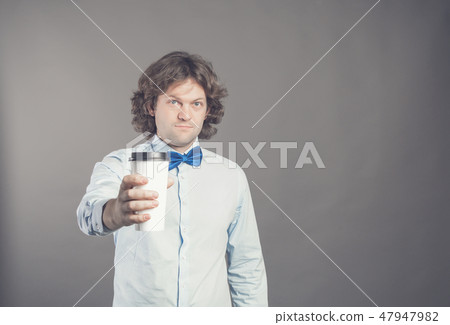 Close up portrait of happy handsome man in blue shirt with paper cup of morning coffee. Good morning Close up portrait of happy handsome man in blue shirt with paper cup of morning coffee. Good morning 47947982