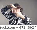 Young handsome man focusing with fingers, framing with hands isolated on grey background. Close up 47948027