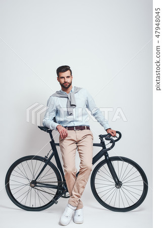 Enjoying urban lifestyle. Full length of stylish young man leaning on his bicycle. Urban style Enjoying urban lifestyle. Full length of stylish young man leaning on his bicycle. Urban style 47948045