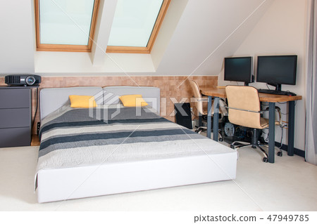 King-size bed with yellow and grey bedding in modern bedroom. Stylish room interior with comfortable King-size bed with yellow and grey bedding in modern bedroom. Stylish room interior with comfortable 47949785