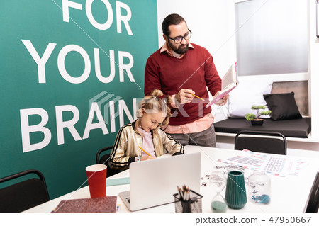 Dark-haired bearded adult teacher in eyewear giving home task to his pupil Dark-haired bearded adult teacher in eyewear giving home task to his pupil 47950667