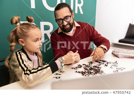 Dark-haired bearded adult teacher in eyewear looking pleased Dark-haired bearded adult teacher in eyewear looking pleased 47950742