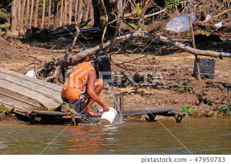 Unrecognizable girl washing her hair along the Rio Parguay river, Pantanal, Corumba, Mato Grosso Do Unrecognizable girl washing her hair along the Rio Parguay river, Pantanal, Corumba, Mato Grosso Do 47950783
