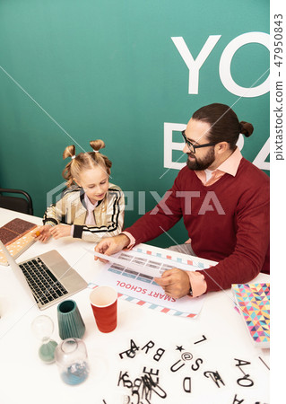 Cute fair-haired girl with bracelets on her hand looking at the pictures Cute fair-haired girl with bracelets on her hand looking at the pictures 47950843