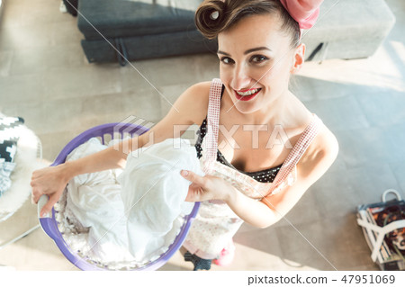 Happy homemaker wife carrying basket with the laundry  47951069