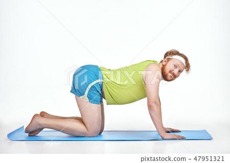 Amusing, red haired, chubby man trains on the mat 47951321