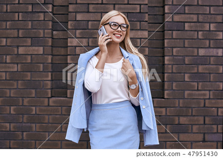 Smiling blonde woman talking on the phone 47951430