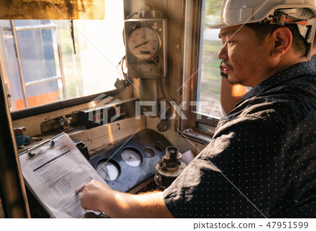 Train driver checking engine of train 47951599