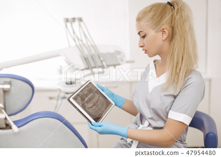 Dentist doctor using digital tablet against dental equipment. Dentist doctor using digital tablet against dental equipment. 47954480