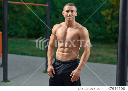 Muscular sportsman with naked torso posing outdoors. Muscular sportsman with naked torso posing outdoors. 47954608