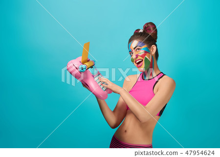 Happy pop art model smiling, holding toy typewriter. 47954624