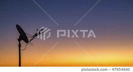 Satellite silhouetted against golden sky at sunset Satellite silhouetted against golden sky at sunset 47954890