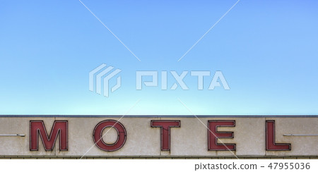Red Motel sign beneath a clear blue sky 47955036
