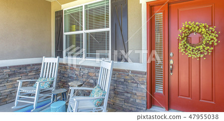 Red front door with wreath and chairs on porch Red front door with wreath and chairs on porch 47955038