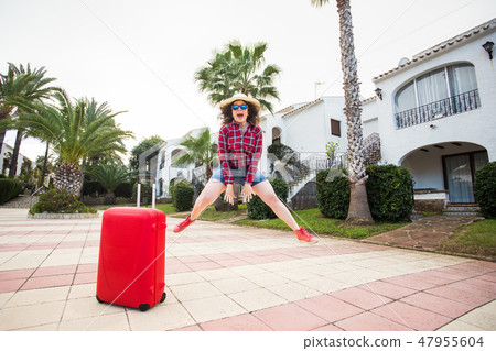 Travel, tourism, emotions and people concept - happy young woman jumped in a hat and sunny glasses 47955604