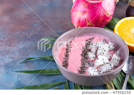 Raspberries red or pink smoothie bowls topped with fresh pitaya and chia seeds on palm leaf on stone Raspberries red or pink smoothie bowls topped with fresh pitaya and chia seeds on palm leaf on stone 47956250