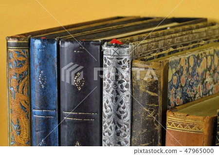 Cultural heritage. Antique books on old wooden shelf. Old books on yellow background. Close up Cultural heritage. Antique books on old wooden shelf. Old books on yellow background. Close up 47965000