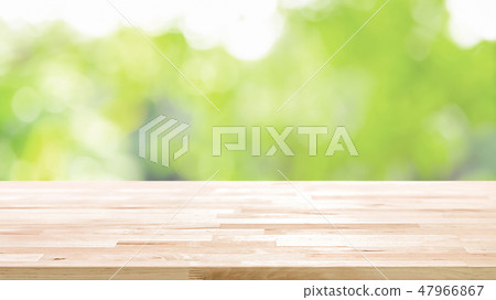 Wood table top on blur abstract green background Wood table top on blur abstract green background 47966867