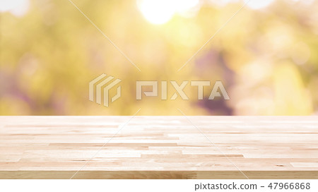 Wood table top on blur abstract foliage background Wood table top on blur abstract foliage background 47966868