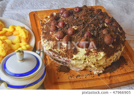 Chocolate cake with cherries, grated chocolate and whipped cream. Homemade cream puffs on festive Chocolate cake with cherries, grated chocolate and whipped cream. Homemade cream puffs on festive 47966905