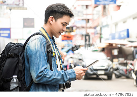 Asian tourist backpacker traveling using tablet 47967022