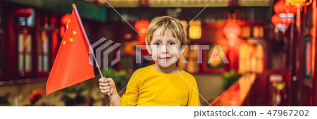Enjoying vacation in China. Happy tourist boy with a Chinese flag on a Chinese background. Travel to 47967202