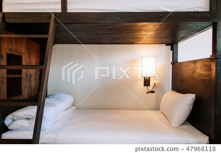 Hostel dormitory beds arranged in room 47968118