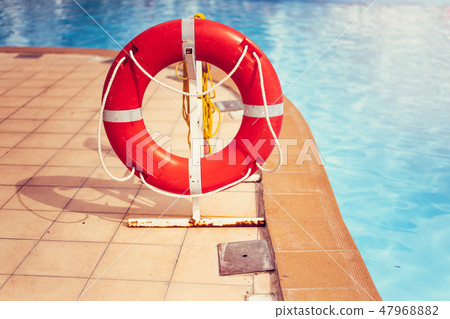 Lifebuoy life ring with rope attached to the post next to the pool in city in tropical country 47968882