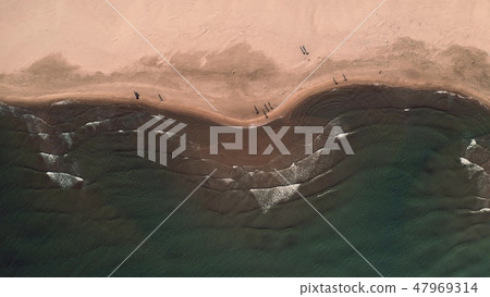 Aerial top down view of sea surf on sand beach and walking people Aerial top down view of sea surf on sand beach and walking people 47969314