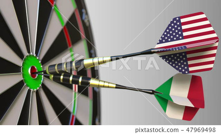 Flags of the USA and Italy on darts hitting bullseye of the target. International cooperation or 47969498
