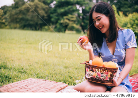 beautiful woman enjoying picnic in a park. beautiful woman enjoying picnic in a park. 47969919