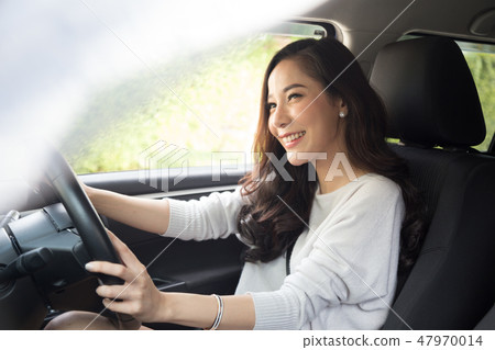 Asian women driving a car and smile happily  47970014