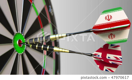 Flags of Iran and the United Kingdom on darts hitting bullseye of the target. International Flags of Iran and the United Kingdom on darts hitting bullseye of the target. International 47970617