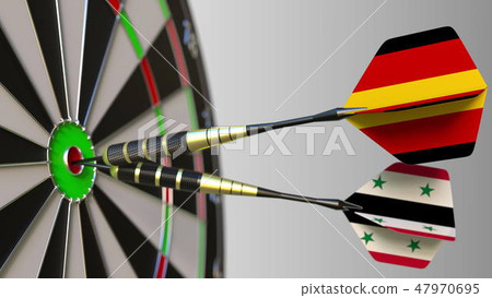 Flags of Germany and Syria on darts hitting bullseye of the target. International cooperation or 47970695
