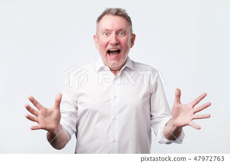 Happy senior man screams with happiness, celebrates his great triumph 47972763