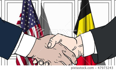 Businessmen or politicians shake hands against flags of USA and Belgium. Official meeting or Businessmen or politicians shake hands against flags of USA and Belgium. Official meeting or 47973243