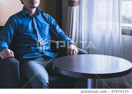 一個男人坐在椅子上 47974155