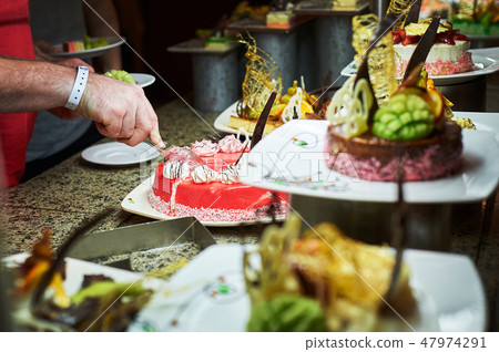 Rows of tasty looking desserts in beautiful arrangements. Sweets on banquet table - picture taken 47974291